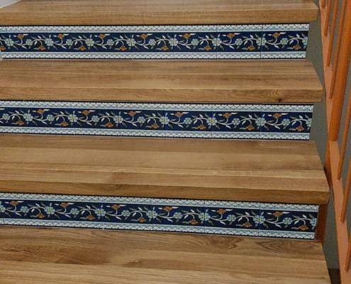 ceramic tiles inserted in a wooden staircase as risers