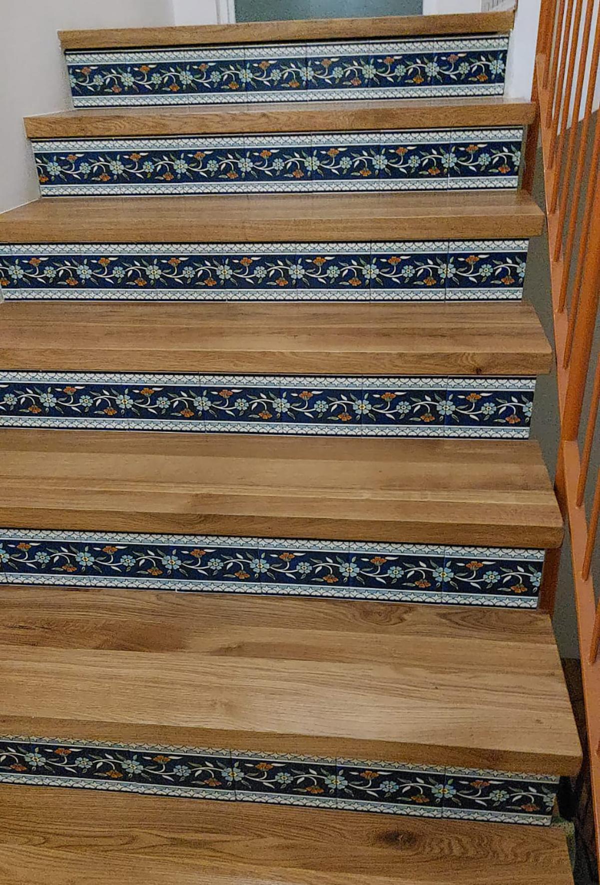 ceramic tiles inserted in a wooden staircase as risers