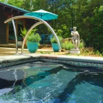 Patterned Balian waterline tiles beside submerged pool entry steps and a curved metal handrail