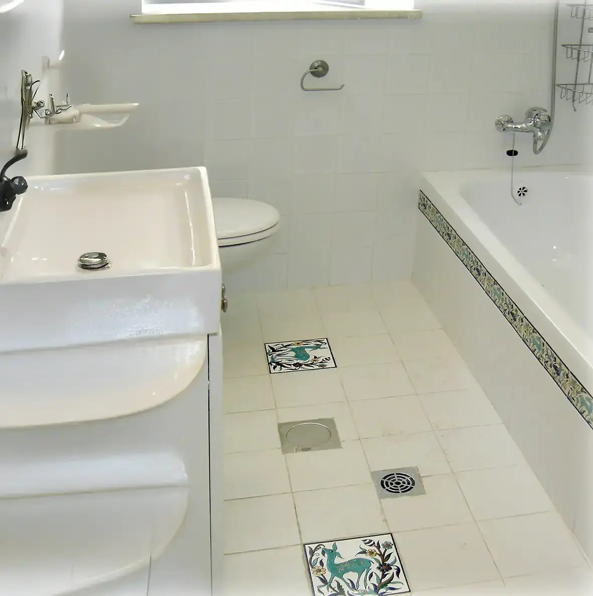 decorative tiles used as floor tile accent tiles and a subway tile border along the bath tub