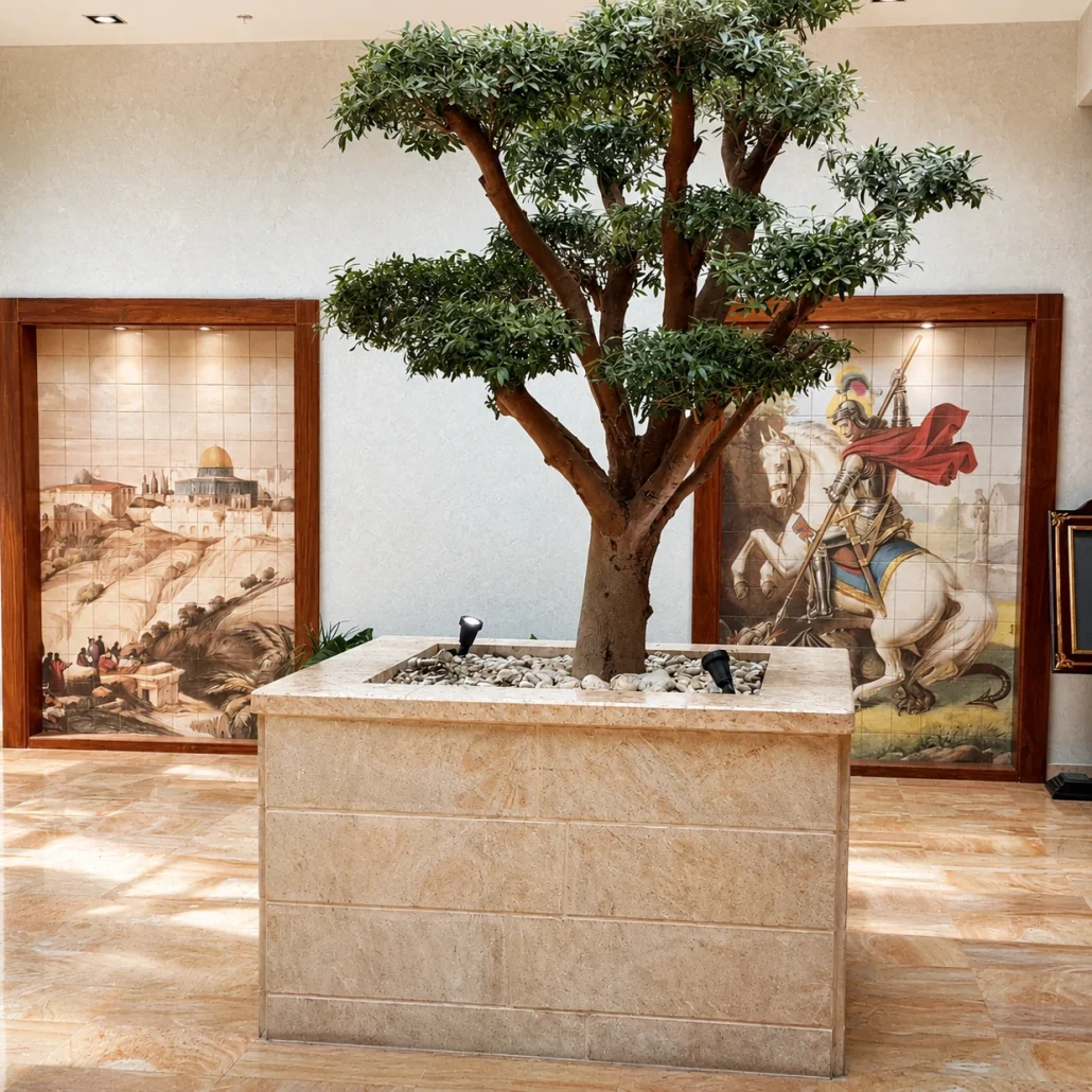 Hand-painted ceramic tile murals flanking a hotel lobby centrepiece, depicting a Jerusalem landscape and a knight on horseback