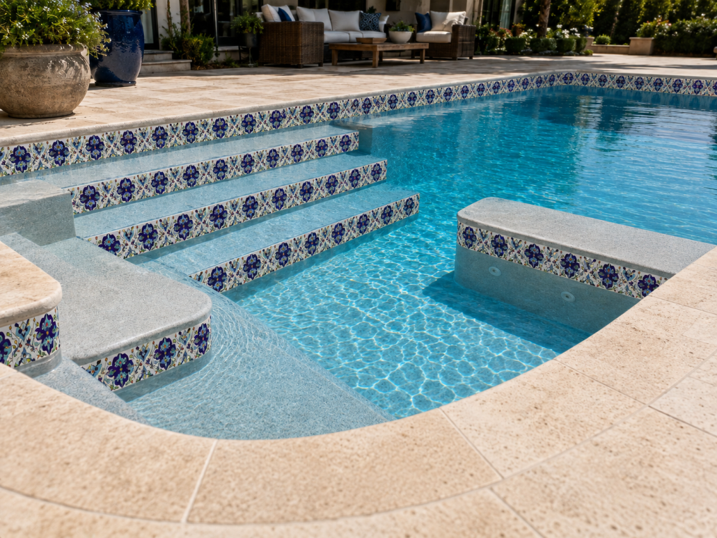 Decorative hand-painted tile on pool step risers in an American Mediterranean pool